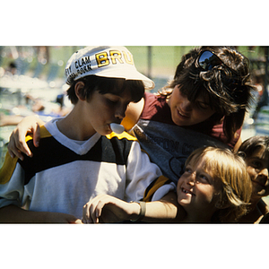 Boy blowing bubblegum while standing next to two friends