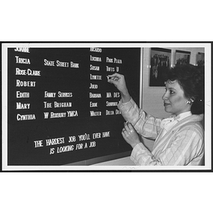 Woman stands at a board, posting letters to it