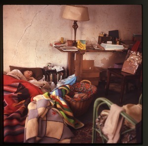 Nina Keller asleep, with baby Eben Light in a basket nearby, Montague Farm Commune