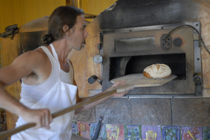 Hungry Ghost Bread: owner and baker Jonathan C. Stevens removing loaves of bread from the oven