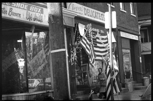 Woman walking past Chewen's Delicatessen in Highland Falls, N.Y., decked out in American flags to welcome home the hostages from Iran
