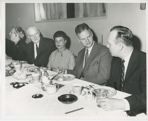 Sam Farnsworth with unidentified woman and men at Thanksgiving celebration