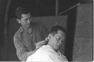Village barber gives haircut to soldier; Luong Hoa Village.