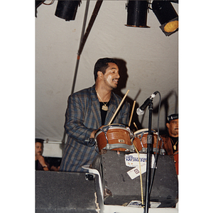 A man plays a drumset on stage at the Festival Puertorriqueño