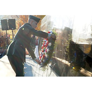 A uniformed man places a wreath on the Veterans Memorial at the dedication ceremony