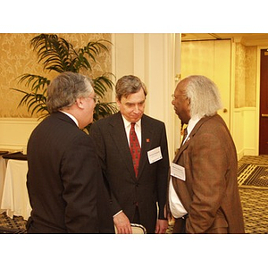 Three men talking at the College of Business Administration's CEO Breakfast forum