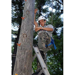 Odalis David Polanco climbs up the Torch Scholars Project Adventure Ropes Course