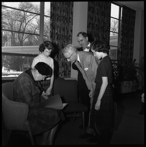 Eleanor Roosevelt (left) seated in the Cape Cod Lounge (Student Union), during Roosevelt's Distinguished Visitors Program appearance at UMass Amherst: John Gillespie in background with bow tie
