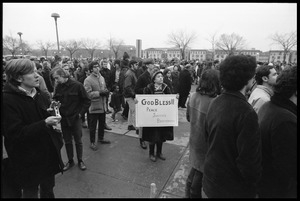 Anti-Vietnam War marchers, one older woman holding a sign reading 'God Bless Peace, Justice, Brotherhood': during the Counter-inaugural demonstrations, 1969