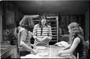 Sammy Wolf, Nick Carson, and Julie Howard (l. to r.) working in commune bakery