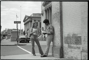 Free Spirit Press crew member sharing copy of the magazine with young African American man on street corner near Springfield City Hall