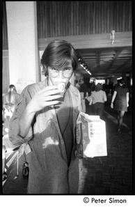 Student sipping from a paper cup : Vietnam War sanctuary at MIT