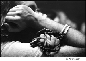 Ram Dass lecture in Boston: man holding mala beads and listening to Ram Dass