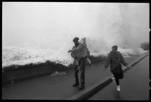 Judy Salonia, her husband Vincent, and daughter Ashley (4) watch as a huge surge crashes over the Narragansett seawall