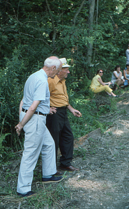 Unidentified man converses with Harvey Cummings (in hat) of Petersburg Road at Moon Barn Raising at entrance to Hopkins Forest on 2 August 1975.