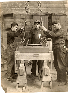 [Students working at a machine]