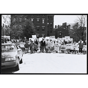 Children marching down the street with their signs during the Boys and Girls Clubs of Boston 100th Anniversary Celebration Parade