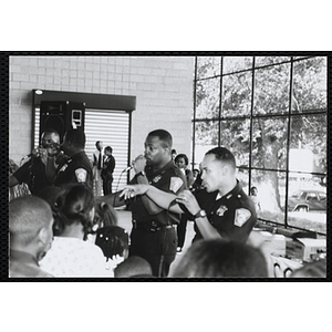 Boston Police officers perform with microphones for children at a public relations event