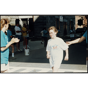 A girl crosses the finish line of the Battle of Bunker Hill Road Race