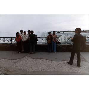 Chinese Progressive Association members gather together at Niagara Falls, with a man holding a camera nearby