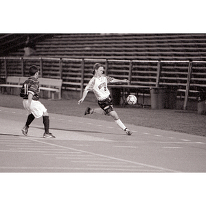 Men's soccer player kicking ball