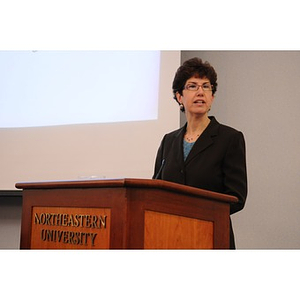 Beth Meltzer speaking from behind a podium at the Holocaust Awareness Breakfast