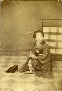 Japanese woman holding calligraphy instruments
