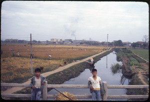 Foshan: two boys on bridge, canal in back, wheat