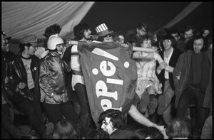 Yippies on stage at the Counter-inaugural Ball, 1969: naked man in an Uncle Sam hat holds up a Yippie! flag