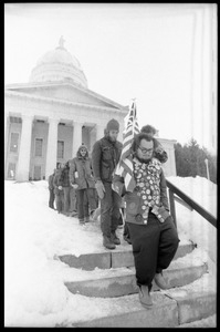 Protesters, led by man carrying an American flag, descending the steps of the Vermont State House during a demonstration against the invasion of Laos