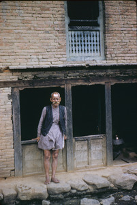 Old man outside his village home