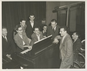 Rosa Rios playing an organ while a group of men look on