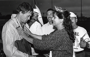 Police Commissioner Francis M. "Mickey" Roache receiving a medal from the queen of the Puerto Rican Festival with Jorge Rivera Ortiz and two unidentified men looking on