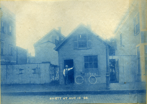 [Man with bicycle in front of house on Swett Street]