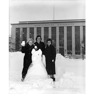 Three women pose with their snow husky