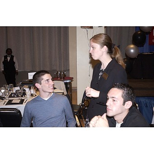 Two students talking at a group table during the Student Activities Banquet