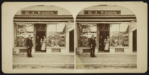 Stereograph of three people in the doorway of H.J. Woods storefront, location unknown, undated