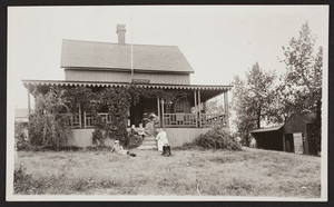 Exterior view of Idlewild Cottage with two women and four children sitting in front, Nahant, Mass., undated