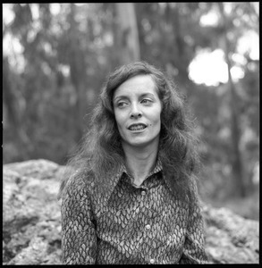 Woman posed on a granite boulder in a eucalyptus grove