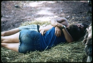 Couple lying in an embrace on the ground at the Woodstock Festival