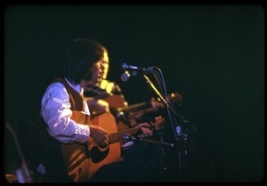 Neil Young on acoustic guitar, playing with Crosby, Stills, and Nash at the Woodstock Festival