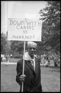Elderly civil rights protester holding sign reading 'Down with canine v. human'