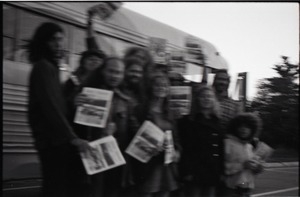 Free Spirit Press crew standing by bus, clutching issues of the magazine (blurry)