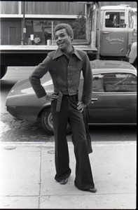 African American man wearing trendy clothes, wide collar, and bell-bottoms