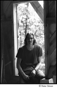 James Taylor's house: Taylor sitting in a window frame of his under construction house