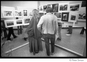 People looking at Peter Simon's photography exhibit at the Kohoutek Celebration of Consciousness