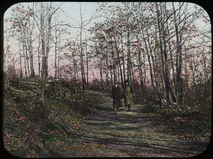 Two woman walking along woodland path in Autumn