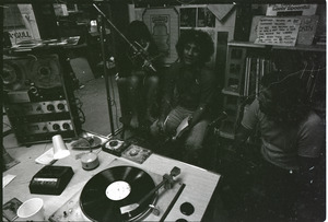 Abbie Hoffman: Hoffman (center) seated at microphone, WBCN studio, holding copy of Steal This Book