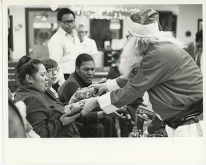 Santa Claus handing gifts to clients at Christmas party