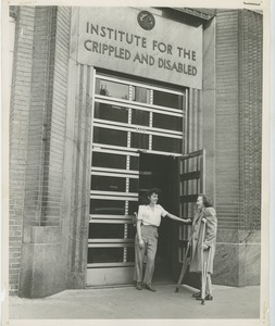 Two women, one using crutches, at the front door of an ICD building